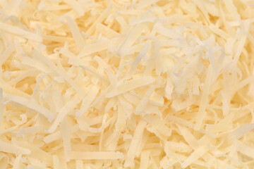 An overhead, close-up shot of a texture made of freshly grated parmesan cheese