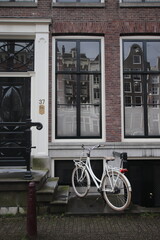 amsterdam canal house in the historical district with bike parked our front. facades of buildings, door of the building