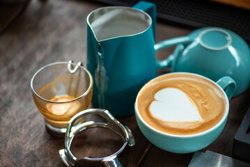 Barista Tools: Latte Art Setup with Portafilter, Milk Jug, and Espresso Cups on Wooden Table Latte...