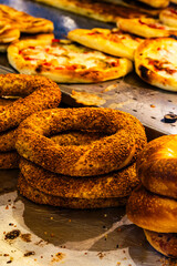 Fresh Turkish simit bread rings displayed on a street vendor’s stall. Traditional cuisine, street food culture, and an authentic Turkish bakery.	