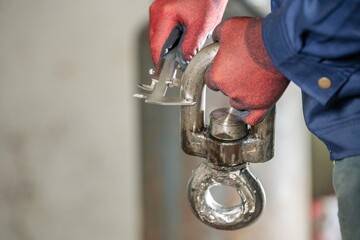 Worker in Red Gloves Measuring Steel Pipe with Caliper Industrial Toolset: Close Up of Hands Gripping Metal Rod and Caliper Technician Checking Surface Roughness with Precision Instrument.