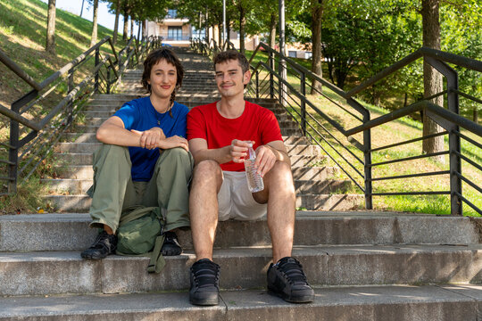 Hikers resting on steps and holding water bottle