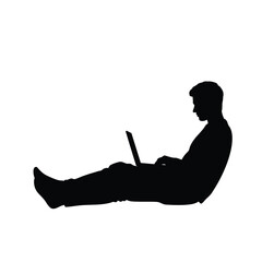 Silhouette of a man sitting on the floor with his legs extended, working on a laptop. This image represents freelance work, remote study, or relaxed digital living.
