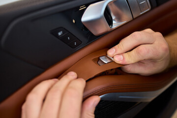 Skilled hands install a car door handle trim, highlighting craftsmanship and precision in design
