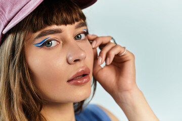 Obraz premium Stylish young woman with unique makeup and fashionable attire showcases modern trends