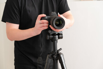 A photographer is meticulously setting up a camera on a sturdy tripod for capturing images