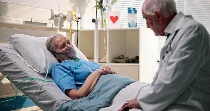 Senior patient, doctor and news in hospital with oxygen mask, chronic illness and discussion for support. Elderly woman, recovery and male physician explaining treatment for medical condition.