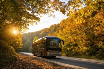 Fototapeta premium A tour bus drives along a scenic road surrounded by vibrant autumn trees under the warm glow of the setting sun