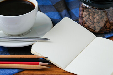 Cup of Coffee with Notebook and Stationery on Wooden Desk