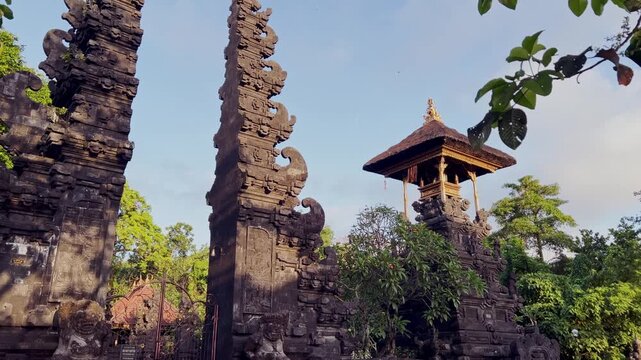 A majestic Bali Hindu temple with a towering gate serves as a spiritual site, surrounded by traditional architecture and sacred details that reflect centuries of devotion and Balinese culture.