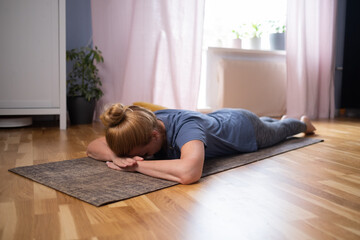 Mature caucasian woman resting after yoga practice in savasana 