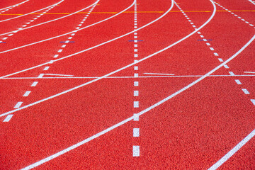 Empty running tracks at an outdoor athletics stadium featuring distinctive white lines and curves