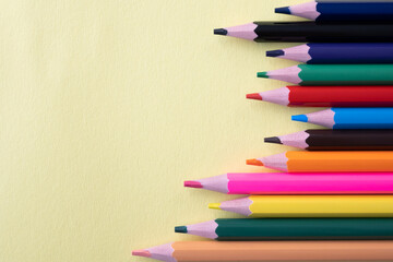 Much colour pencils on the yellow background. Space for text.