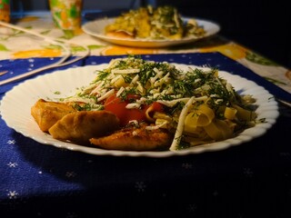 Delicious pasta dish with grilled chicken and fresh dill served on a white plate for a tasty dinner