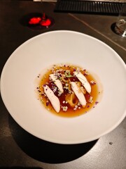 Exquisite chicken noodle soup presented in a stylish white bowl on a dark restaurant table