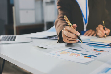 Focused young businessman signing agreement with skilled lawyer in eyeglasses. Concentrated financial advisor showing place for signature on paper contract document to male client at meeting in office