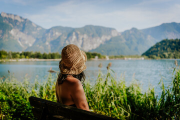 young mid adult tourist woman enjoys holidays at a mountain lake in Levico on a sunny summer day smiling
