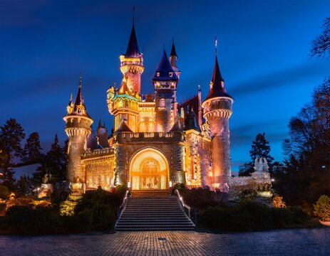 a beautifully illuminated castle stands majestically at night in a theme park creating a fairytale like ambiance with glowing warm lights and enchanting atmosphere