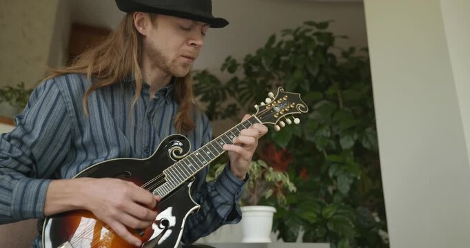 Male Musician Plays Mandolin. Caucasian Man Enjoys Playing Music 4K 10-bit