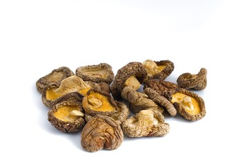 An artistic display of dried shiitake mushrooms on white, emphasizing their textured surfaces and organic colors.