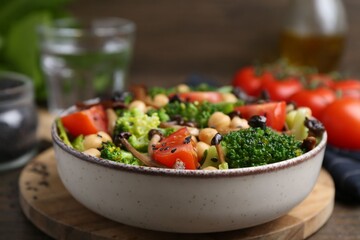 Delicious salad with shimeji mushrooms, chickpeas, tomatoes and broccoli on table, closeup