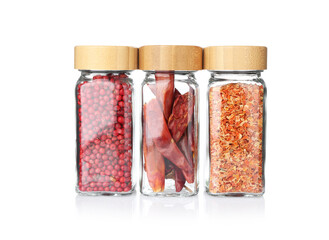 Different aromatic spices in glass jars isolated on white