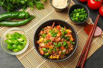 Delicious fried rice in bowl served on grey table, flat lay