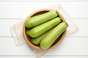 Fresh ripe zucchinis on white wooden table, top view