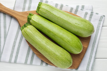 Fresh ripe zucchinis on white wooden table, top view