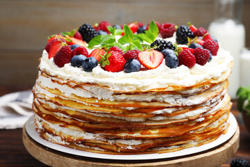Delicious crepe cake with fresh berries on table, closeup