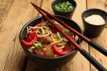Tasty noodles with chicken and vegetables served on wooden table, closeup