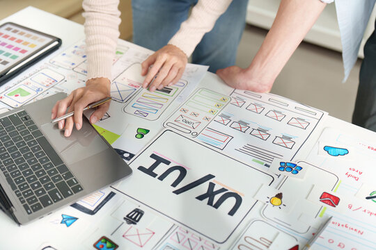 UXUI design collaboration with sketches and digital tools on workspace