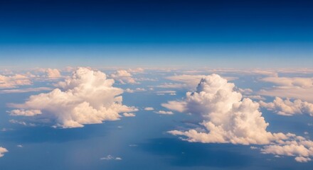 Obraz premium Fluffy white clouds drift over a blue ocean under a clear sky