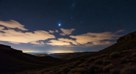 Starry desert night sky above a city skyline with rolling hills