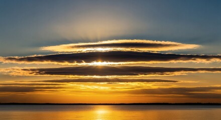 Sunset over calm water with layered clouds