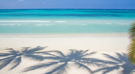 Tropical beach with clear turquoise water and white sand palm shadows