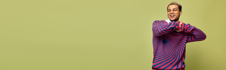 Young stylish african american man enjoys a casual moment in trendy striped sweatshirt