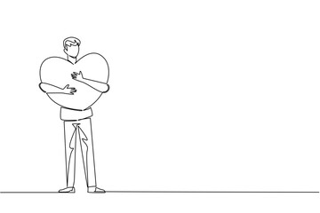A continuous line drawing of a young man hugging a large heart close to his chest, symbolizing care, affection, and unity for Love Conquers All Day in a relationship and compassion concept.