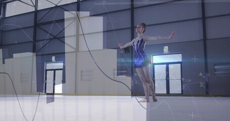 Balancing dancer in sequined leotard on one leg in sports hall, with digital overlay visualization