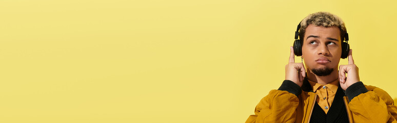 Young man wearing stylish bomber jacket enjoys music in vibrant studio setting