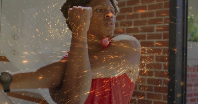 Stretching man in red tank top pulling arm across chest at gym, with smartwatch and rig - Powered by Adobe