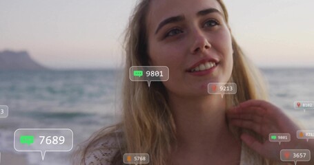 Standing female wearing crochet top gazing at sunset beach, with digital comment and heart icons