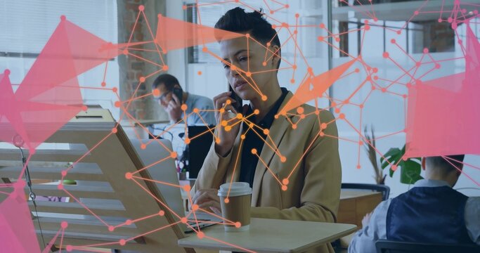 Holding coffee cup businesswoman speaking on smartphone in open office with network overlay - Powered by Adobe