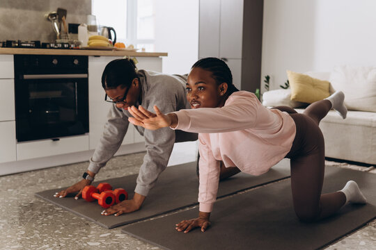Two black women exercising together in their living room