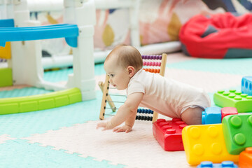 Baby Crawling Among Colorful Toys in Kindergarten. Early development