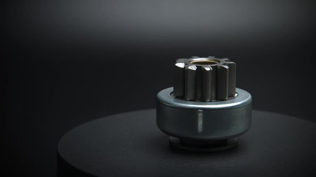 Car starter drive, bendix. Starter part, rotation on black background close-up. Spare parts.