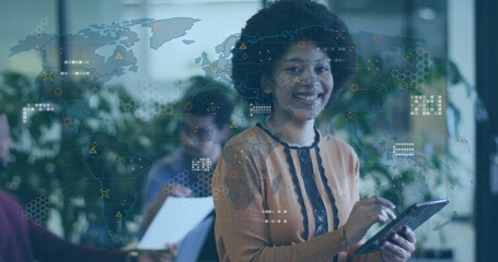 Smiling African American woman holding tablet at modern office, with digital data overlays