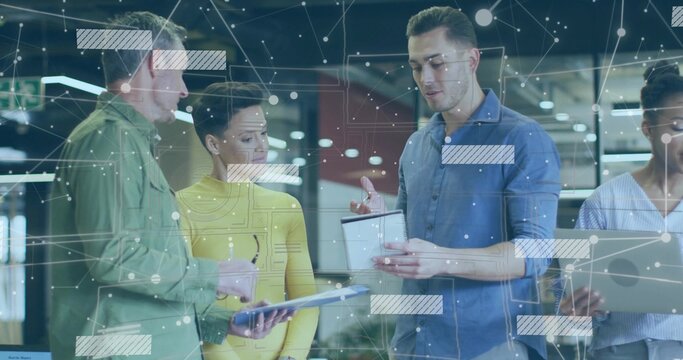 Colleague in blue shirt holding tablet explaining diagram in office, with team laptop and overlays
