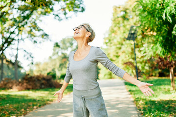 Happy active senior woman meditating and daydreaming and relaxing and nature outdoors