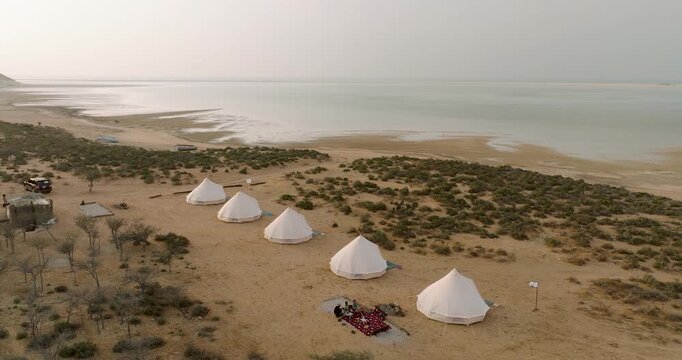 Aerial view of pristine white tents contrasting against the sandy landscape and turquoise waters of Detwah Lagoon, Detwah lagoon, Socotra, Yemen.